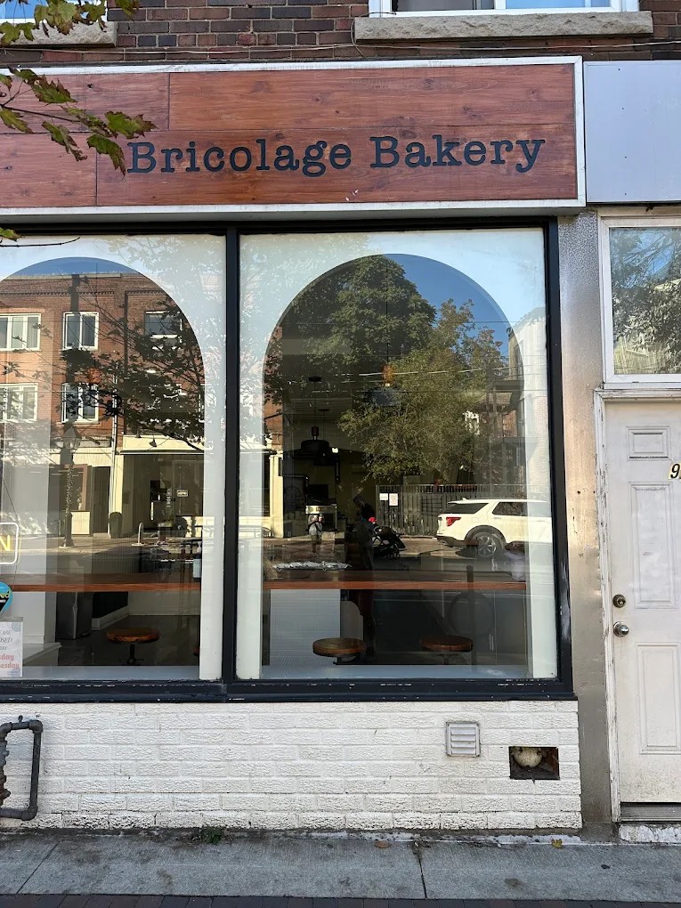 Bricolage Bakery storefront on College Street with wood sign and arched window details
